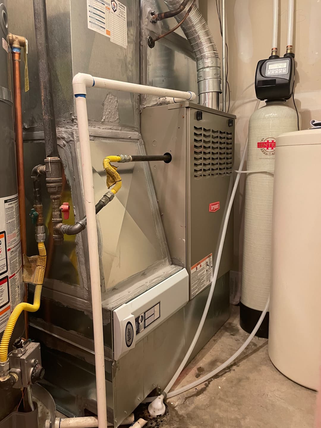 Residential heating system with furnace, water heater, and plumbing components.