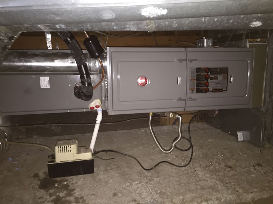 Furnace and air conditioning unit installed in a basement space.