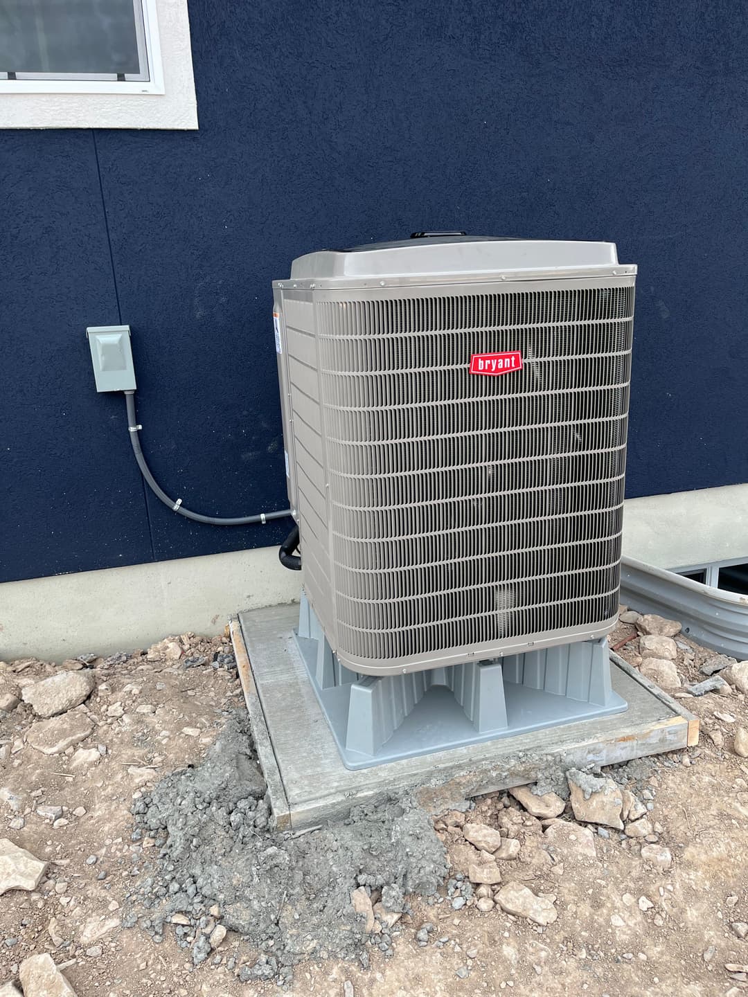 Bryant air conditioning unit installed outside a building on a gravel base.