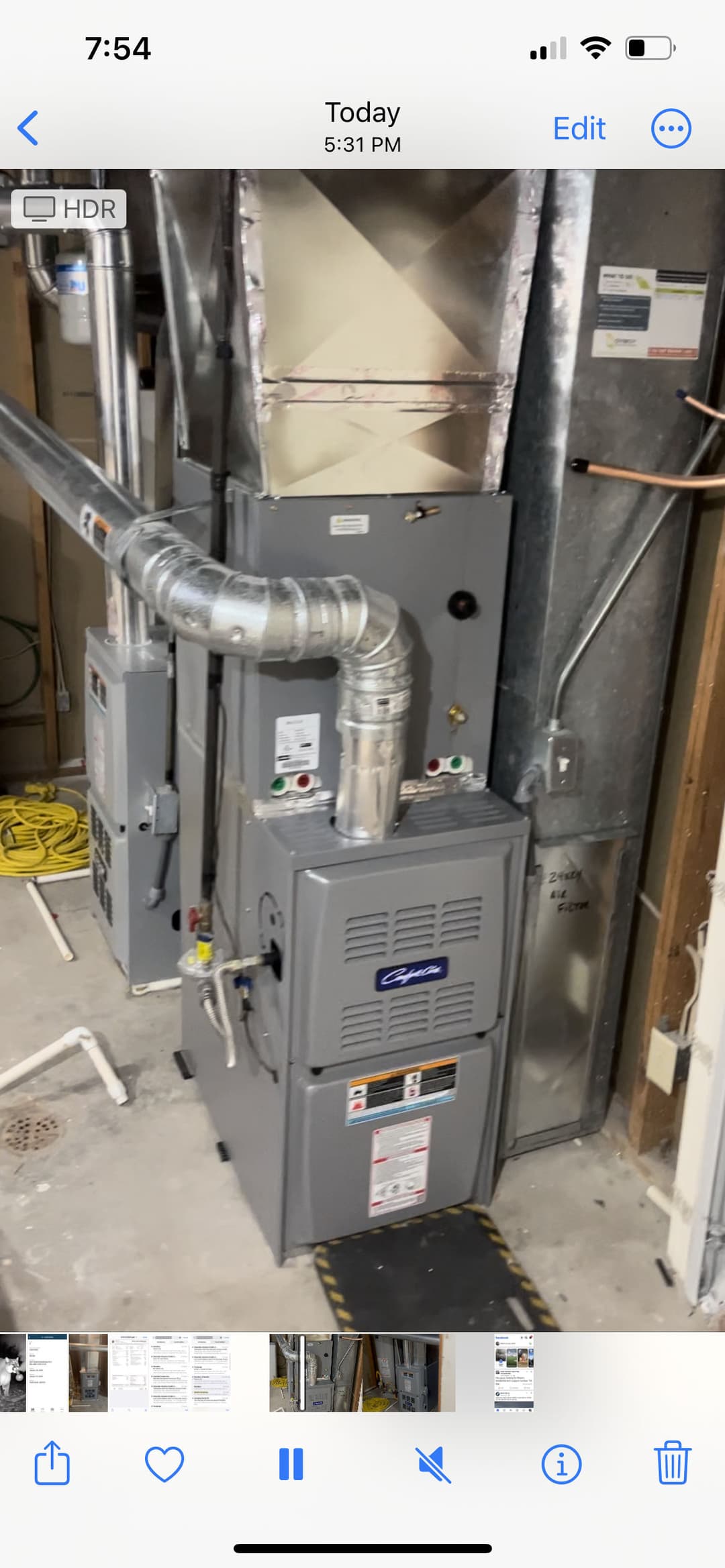 Gray furnace with ductwork in a residential basement setting.